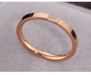Nahaufnahme eines roségoldenen Titanrings mit einzelnem Diamanten in Quadratfassung