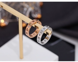 Close-up of rose gold and silver Roman numeral rings with zircon on a display stand