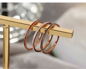 Detailed macro view of minimalist thin rings with colorful red, white, and black enamel inlay
