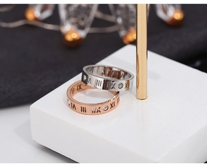 Macro view of Roman numeral engraved rings with inlaid zircons in silver and rose gold