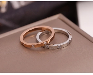 Detail of rose gold and silver rings with brushed texture and small zircon inlay