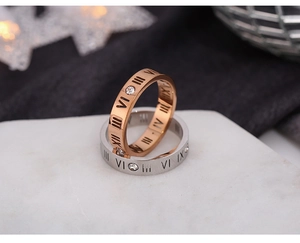 Close-up of rose gold and silver rings with Roman numeral engravings and cubic zirconia