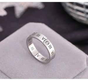 Macro shot of silver roman numeral ring with zircon stones on velvet cushion