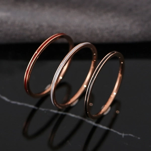 Minimalist rose gold stackable rings with red, white, and black enamel stripes