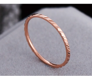 Dettaglio dell'anello in titanio oro rosa 18K con texture geometrica a taglio diamante