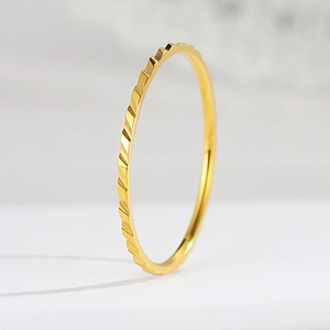 Dettaglio anello in acciaio al titanio oro rosa con texture geometrica sfaccettata a diamante