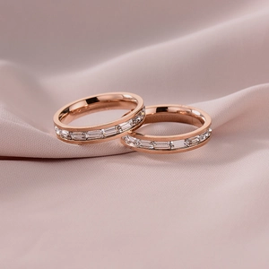 Elegante roségouden titanium ringen met rechthoekige zirkoon op een zachte satijnen stof