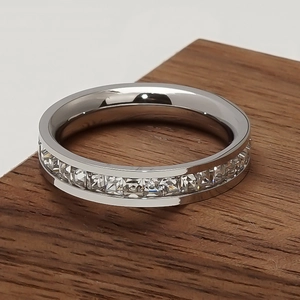 Macro shot of silver stainless steel eternity ring with channel set princess cut crystals