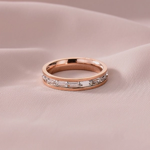 Elegante roségouden titanium ring met een band van rechthoekige zirkonia-stenen