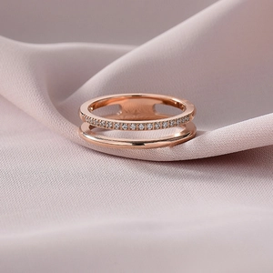 Gros plan sur une bague double couche en or rose avec sertissage pavé de zircons