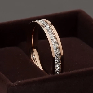 Close-up of rose gold stainless steel ring with square cut crystals in a jewelry box
