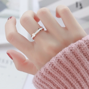 Minimalistischer Ring in Roségold mit weißer Keramik am Finger des Models in sanftem Licht
