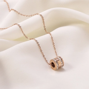 Detail of rose gold cylinder pendant with double-row crystals and Roman numerals