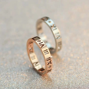 Nahaufnahme von roségoldenen und silbernen Ringen mit römischen Ziffern und Diamanten