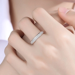 Makro-Detailansicht des silbernen Titanrings mit schimmerndem Sandstrahl-Finish am Finger