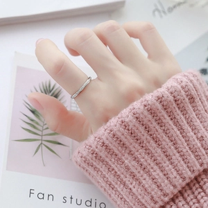 Detailansicht eines minimalistischen Silberrings mit Zirkon-Besatz am Finger