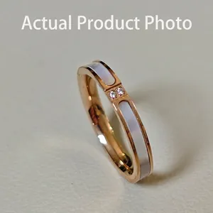 Vista macro de anillo en oro rosa con nácar blanco incrustado y dos circonitas redondas