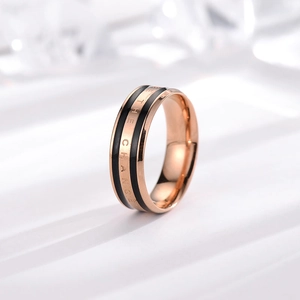 Polished rose gold and black stainless steel ring engraved with BE THE CHANGE text