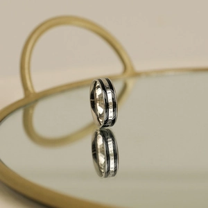 Detail of silver stainless steel ring featuring THE CHANGE engraving on black inlay