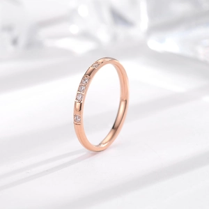Detalle del anillo minimalista de oro rosa de 18k con cinco cristales redondos brillantes