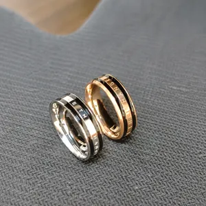 Macro shot of silver and rose gold stainless steel rings with black letter engraving