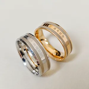 Detailed view of silver and rose gold rings with engraved BE THE CHANGE text