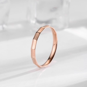 Anillo minimalista de acero de titanio oro rosa con textura cepillada y facetas chic