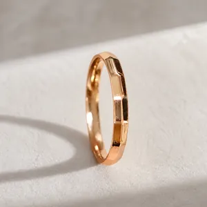 Detalle de un anillo de titanio oro rosa con un diseño de superficie geométrica facetada
