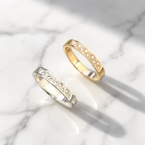 Detailed view of silver and rose gold rings with geometric patterns and small crystals