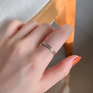 Elegante anello in acciaio al titanio oro rosa con otto zirconi sulla mano donna