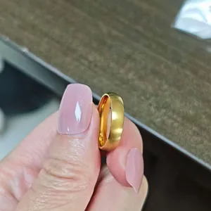 Nahaufnahme eines gebürsteten 18 Karat Gold Titanstahlrings, in der Hand gehalten