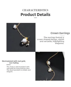 Détail de boucles d'oreilles couronne dorées avec chaîne longue et pendentif perle baroque