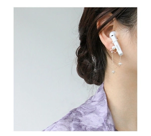 Détail d'une chaîne de boucles d'oreilles anti-perte dorée étoilée avec perles