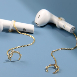 Vue détaillée de chaînes d'oreilles dorées anti-perte pour écouteurs sans fil avec cristaux