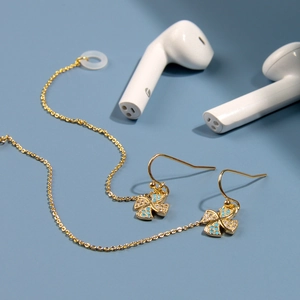 Détail de la boucle d'oreille anti-perte dorée avec trèfle en zircon et boucle