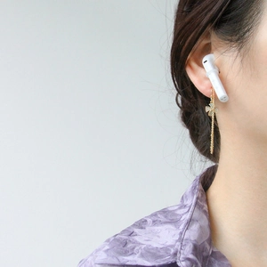Gros plan d'une boucle d'oreille trèfle à quatre feuilles dorée avec cristaux sur un mannequin