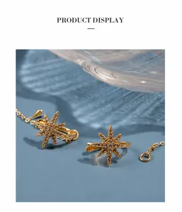 Détails macro des boucles d'oreilles étoile dorées serties de zircons avec chaîne fine
