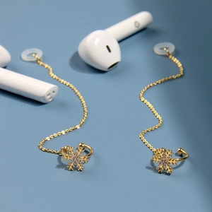 Détail de manchette d'oreille dorée avec chaîne anti-perte et boucle pour les écouteurs