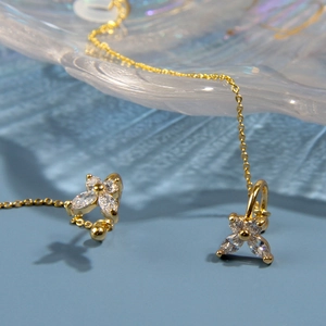 Détail de clips d'oreilles anti-perte dorés avec fleurs en zircon et longues chaînes