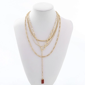 Layered gold necklace with four different chains and a vintage red stone pendant