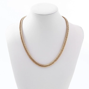 Close-up of golden chunky woven chain necklace displayed on a white neck mannequin bust