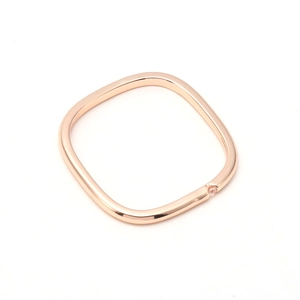 Detailed close-up of rose gold square ring with a small round zircon inlay on a white background