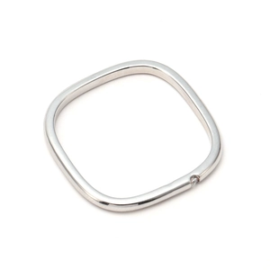 Macro shot of silver square ring with a tiny embedded zircon on a white background