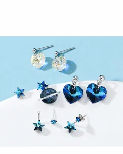 Detailed macro view of silver star and heart earrings with blue Austrian crystals