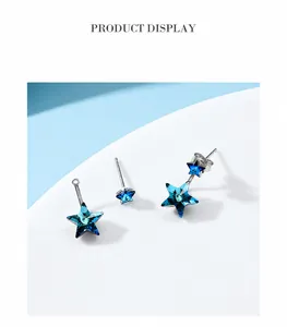 Detail of star-shaped silver earrings with blue Austrian crystals in detachable two-piece design