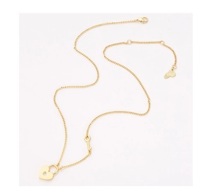 Detailed close-up of gold heart lock and key pendants with sparkling zircon stone