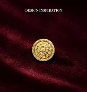Close-up of golden vintage geometric round earring with embossed textures and woven edges