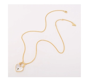 Detail of gold heart lock pendant with white enamel inlay and zircon accents on fine chain