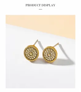 Macro detail of golden circular stud earrings with vintage granulation texture