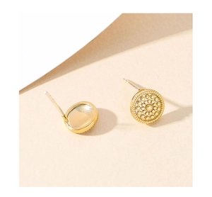 Macro detail of vintage gold disc earrings featuring sunburst relief and smooth concave back